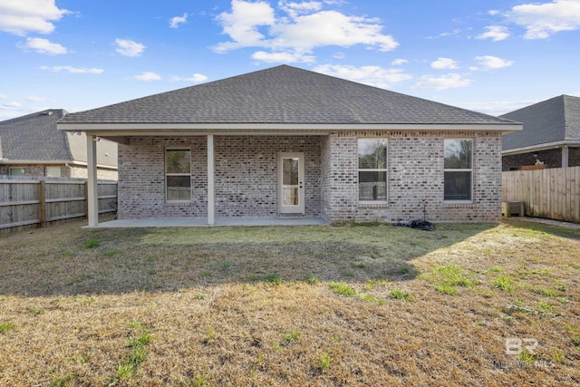 back of house with a yard and a patio