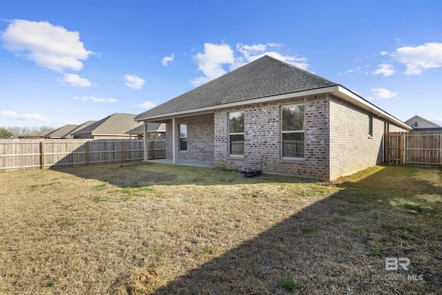 rear view of house with a patio and a lawn