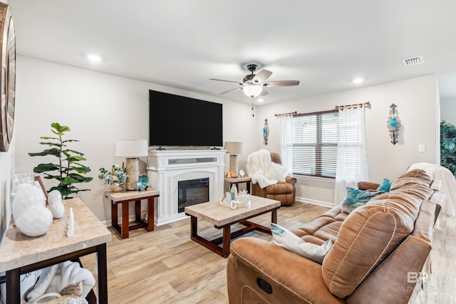 living room with ceiling fan and light hardwood / wood-style flooring