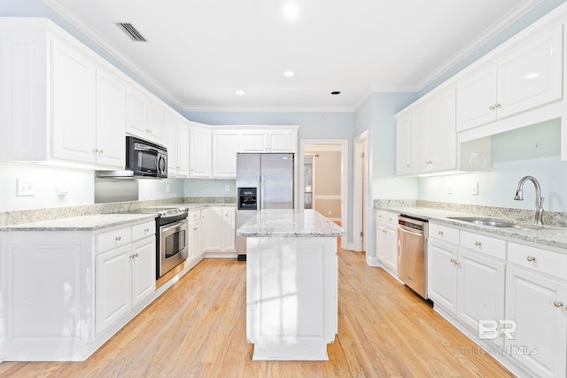 kitchen featuring light stone counters, stainless steel appliances, sink, and white cabinets