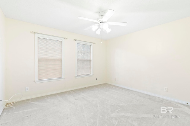 empty room featuring light colored carpet and ceiling fan