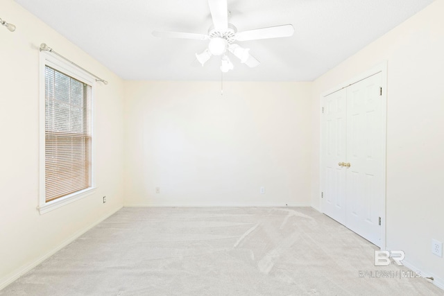 carpeted spare room featuring ceiling fan