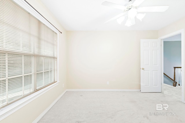 carpeted spare room featuring ceiling fan