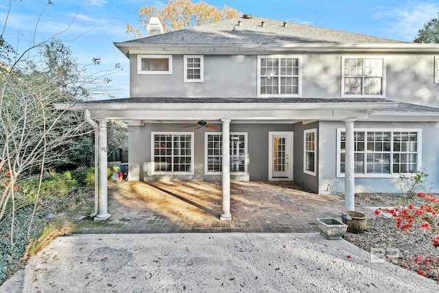 rear view of property with ceiling fan and a patio area