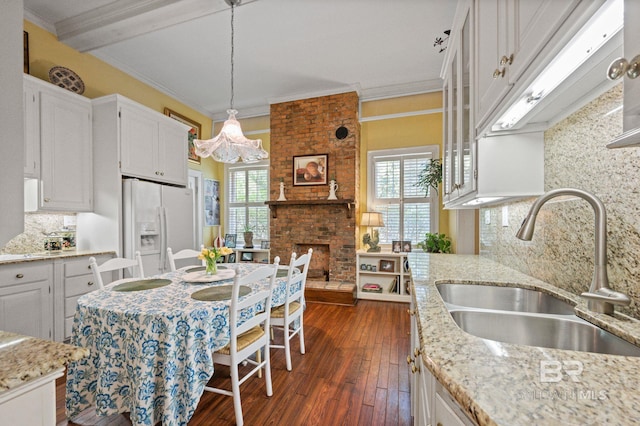 2550 Springhill Ave, Mobile, AL 36607 - kitchen with a chandelier, a sink, white fridge with ice dispenser, tasteful backsplash, and white cabinetry