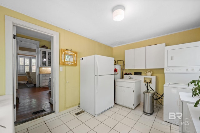2550 Springhill Ave, Mobile, AL 36607 - clothes washing area with cabinet space, stacked washer and clothes dryer, visible vents, and a sink