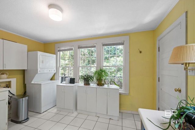 2550 Springhill Ave, Mobile, AL 36607 - laundry room with cabinet space, stacked washing maching and dryer, ornamental molding, and light tile patterned floors