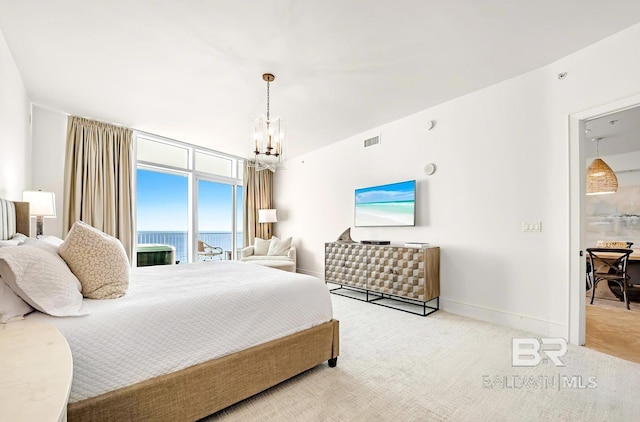 carpeted bedroom featuring an inviting chandelier