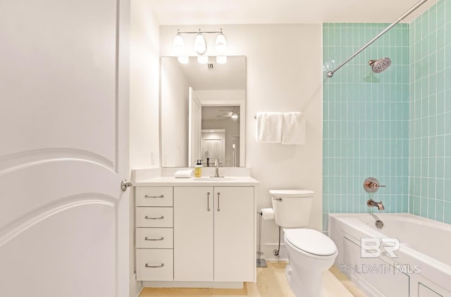 full bathroom with toilet, tiled shower / bath, and vanity