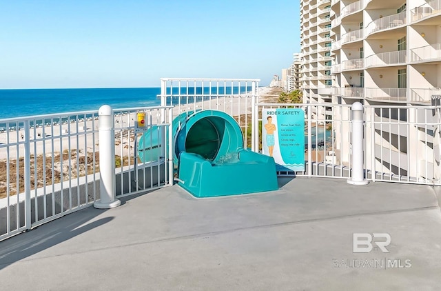 balcony with a water view and a view of the beach