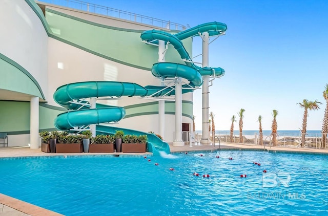 view of swimming pool featuring a water view and a water slide