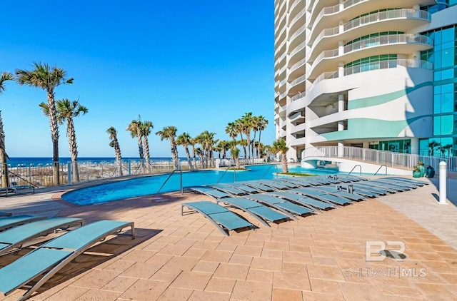 view of swimming pool featuring a patio area and a water view