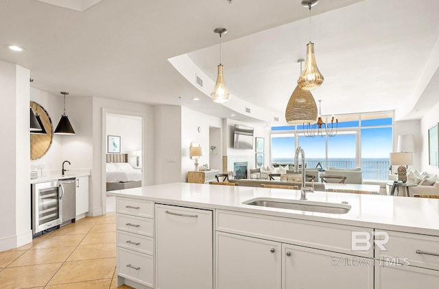 kitchen featuring wine cooler, sink, white cabinets, floor to ceiling windows, and light tile patterned floors