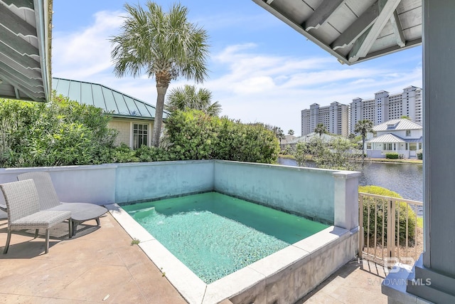 view of pool with a patio area and a water view