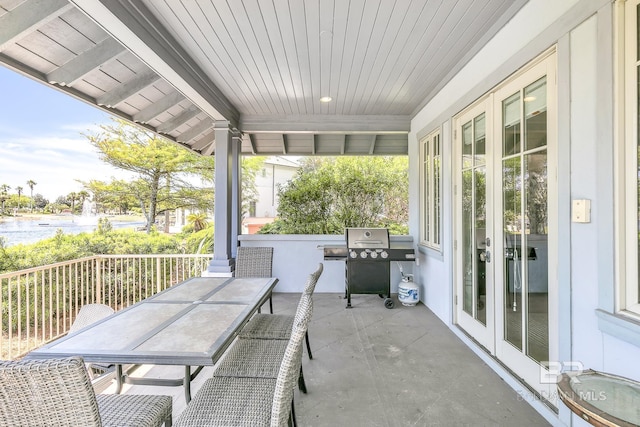 view of patio / terrace with a water view, area for grilling, french doors, and outdoor dining area