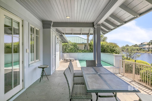 view of patio featuring a water view and outdoor dining area
