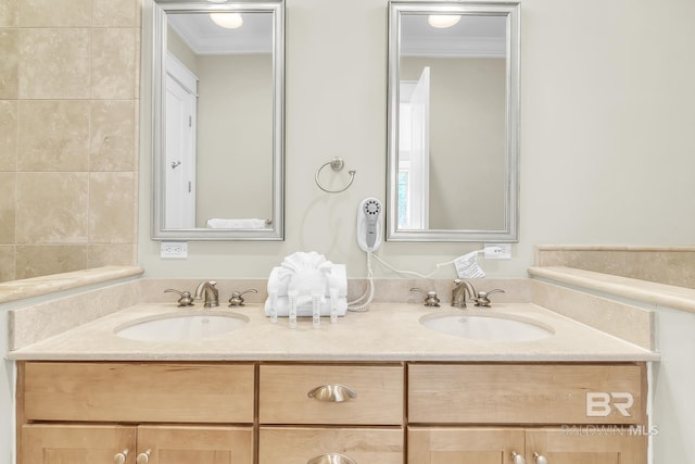 full bath with ornamental molding, double vanity, and a sink
