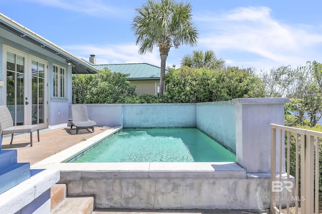 view of pool with fence, a patio, a fenced in pool, and french doors