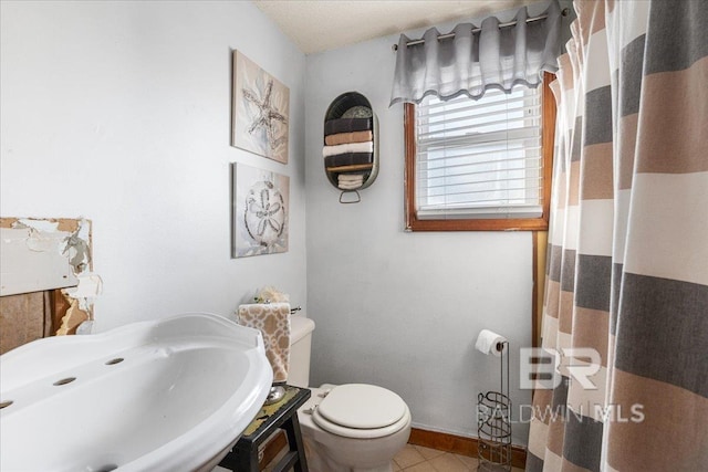 bathroom featuring tile patterned floors, toilet, and sink