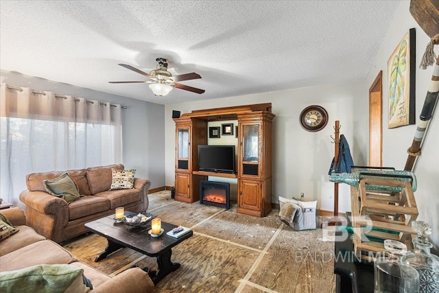 living room with a textured ceiling and ceiling fan