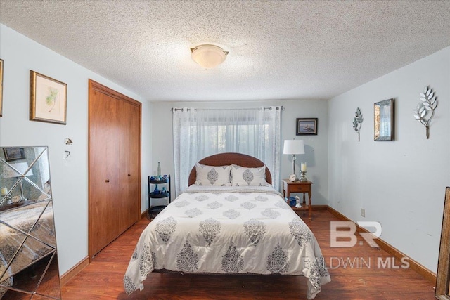 bedroom featuring hardwood / wood-style flooring, a textured ceiling, and a closet