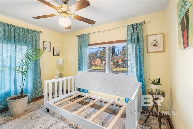 bedroom featuring ceiling fan and a textured ceiling