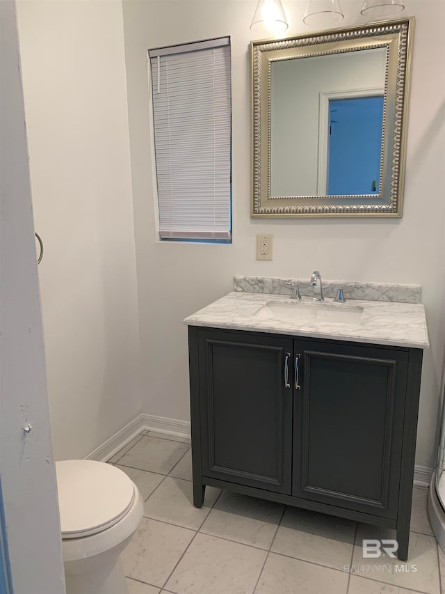 bathroom with vanity, toilet, and tile patterned floors