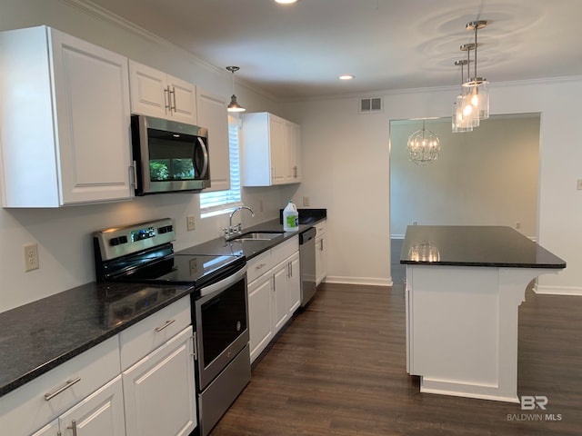 kitchen featuring an inviting chandelier, dark hardwood / wood-style floors, appliances with stainless steel finishes, sink, and white cabinetry