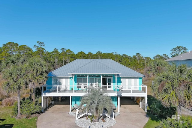 back of property featuring metal roof, a carport, and driveway