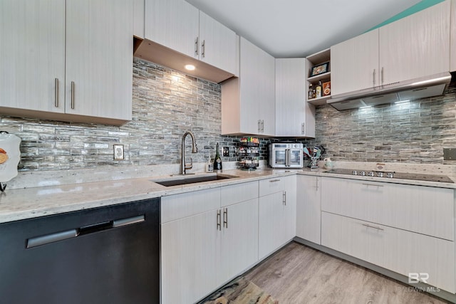 kitchen with a sink, light wood-style floors, ventilation hood, dishwasher, and open shelves