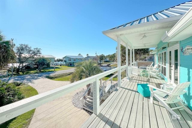 wooden terrace with a porch, a residential view, and ceiling fan