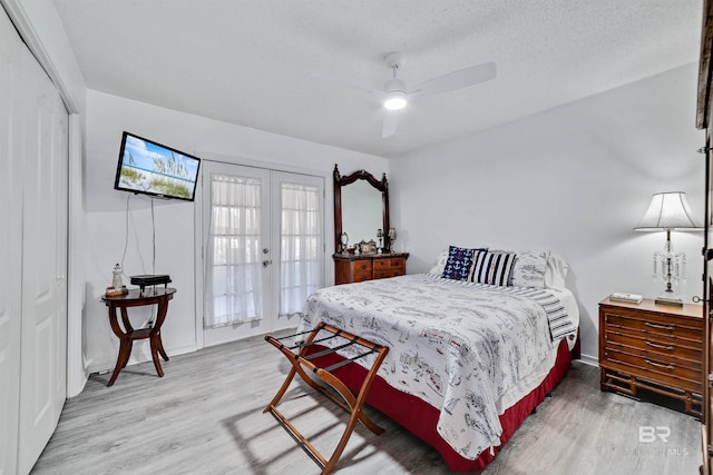 bedroom featuring ceiling fan, a textured ceiling, french doors, a closet, and light wood finished floors