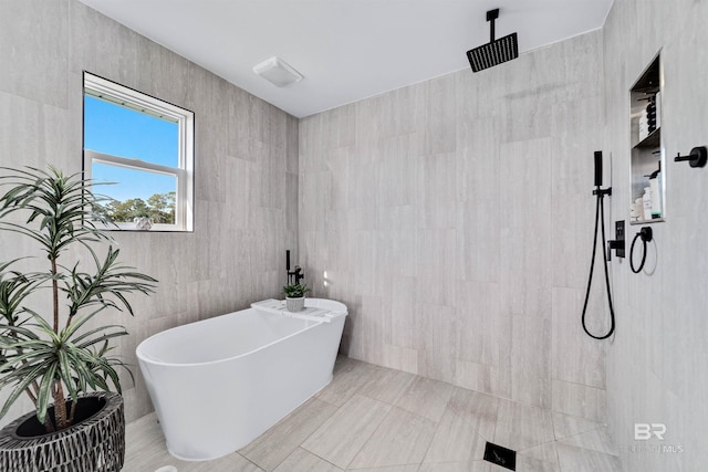 bathroom with a freestanding bath, tile walls, and a walk in shower