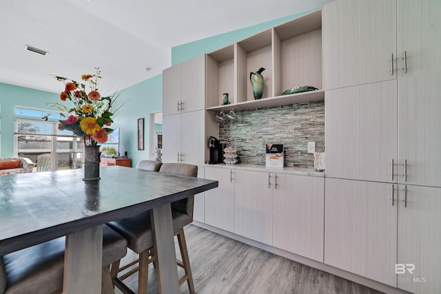 kitchen with visible vents, light wood-style flooring, and open shelves