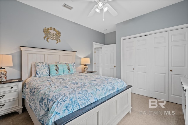 bedroom featuring a closet, light colored carpet, and ceiling fan