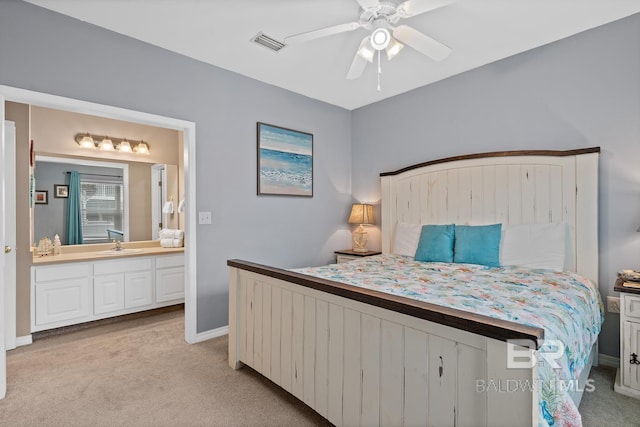 bedroom featuring connected bathroom, ceiling fan, sink, and light carpet