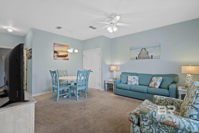 living room with ceiling fan with notable chandelier and light colored carpet