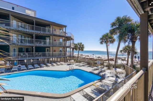 view of swimming pool featuring a patio and a water view