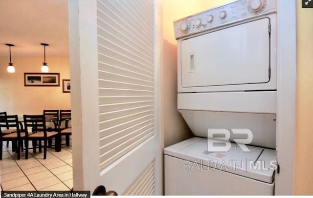 washroom with light tile patterned floors and stacked washing maching and dryer