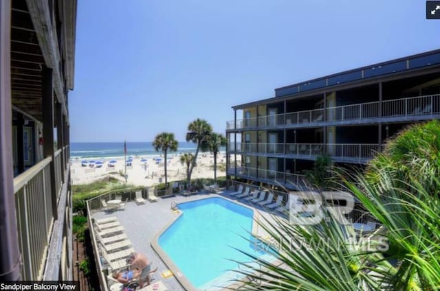 view of pool with a beach view, a patio, and a water view