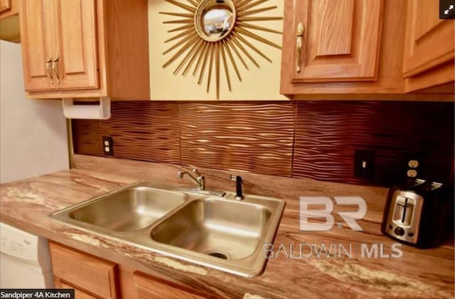 kitchen featuring white dishwasher, tasteful backsplash, and sink