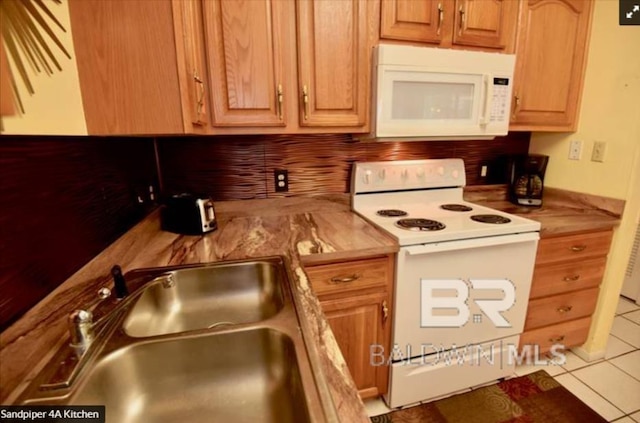 kitchen featuring white appliances, sink, and light tile patterned floors