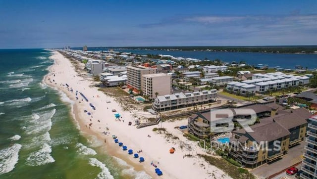 drone / aerial view featuring a water view and a view of the beach