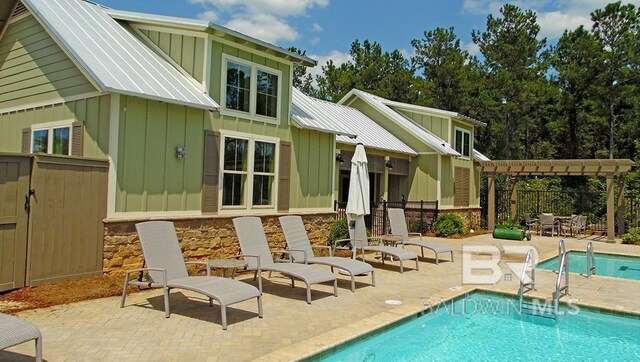 rear view of property featuring a pergola, a fenced in pool, and a patio