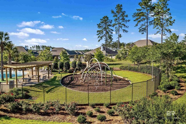 view of play area featuring a lawn and a pergola