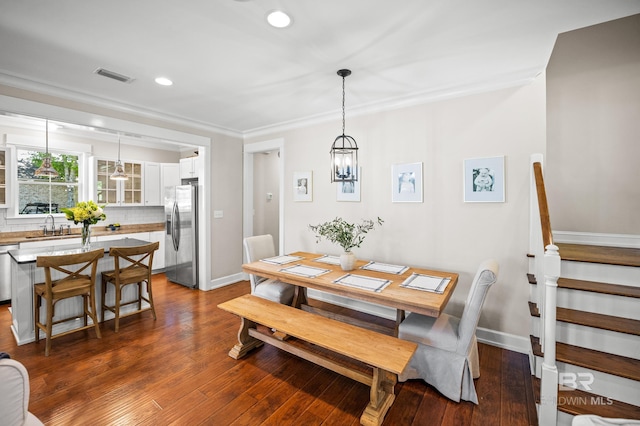 dining area featuring crown molding, dark wood finished floors, and visible vents