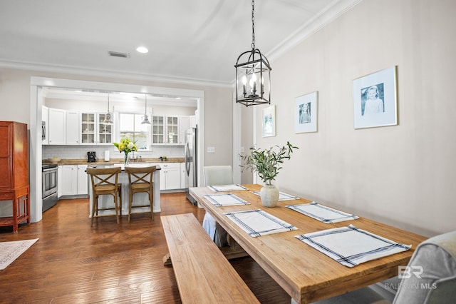 dining room with crown molding, an inviting chandelier, visible vents, recessed lighting, and dark wood-style flooring
