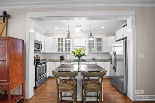 kitchen with stainless steel appliances, glass insert cabinets, dark wood-style flooring, and crown molding