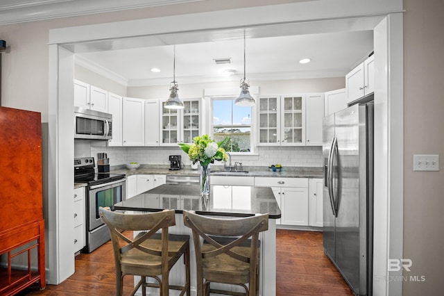kitchen with stainless steel appliances, tasteful backsplash, dark wood-style flooring, and ornamental molding