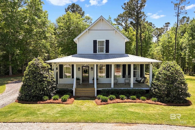 view of front of house with a porch, metal roof, a standing seam roof, and a front lawn
